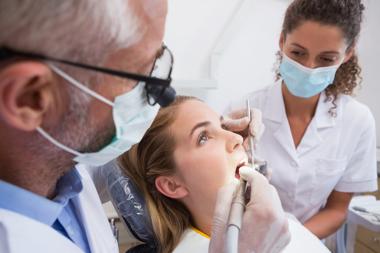 a patient is getting dental cleaning in a dental office.